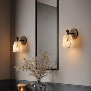 Modern brass wall sconce set with alabaster stone shade, minimalist bedroom wall lighting on grey background Mid century brass wall lights with white alabaster tulip shades, luxury wall sconce pair for bedroom decor Set of two brass wall sconces with natural alabaster shades, elegant modern wall lighting fixture Minimal brass wall lamps with alabaster shade, bedside wall lighting pair on neutral grey wall Luxury brass wall sconce pair with alabaster tulip glass shade, modern wall lighting.