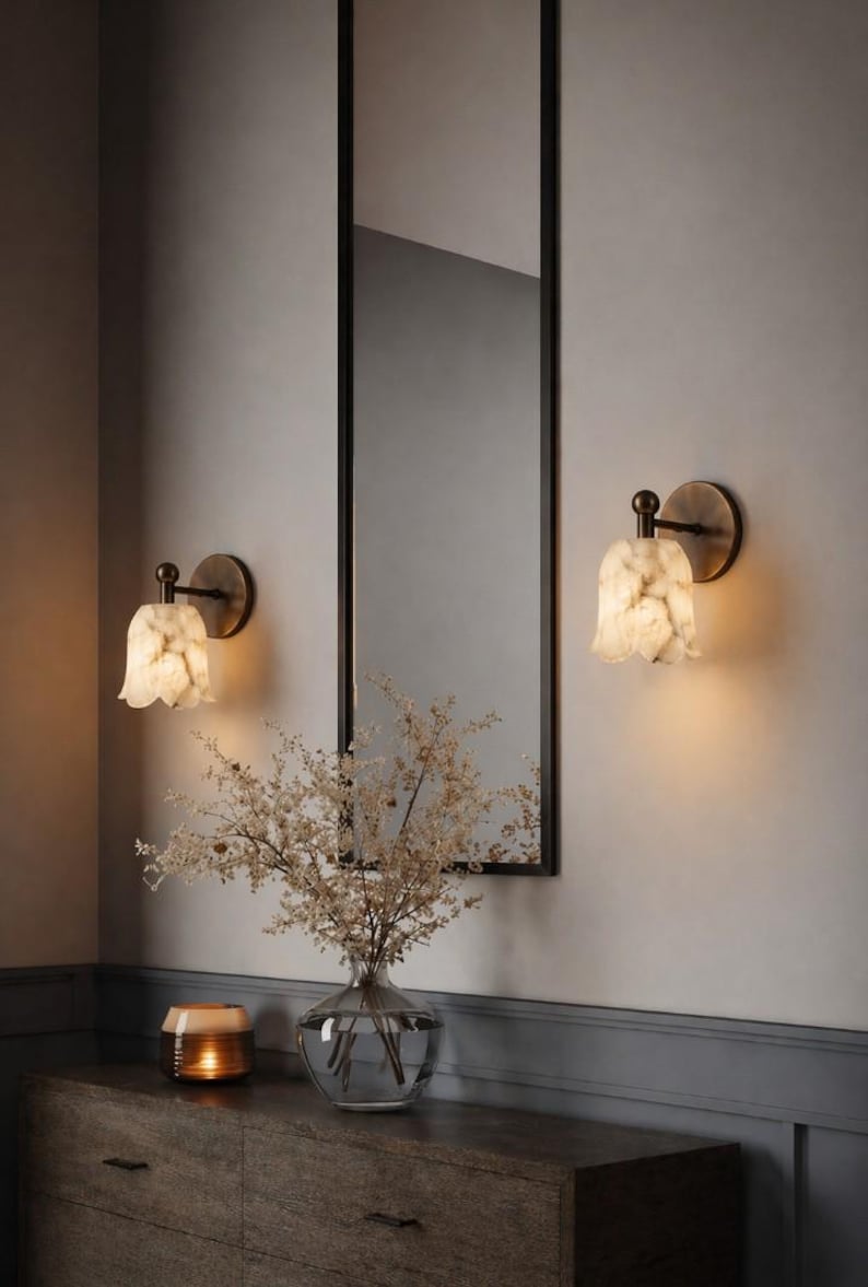Modern brass wall sconce set with alabaster stone shade, minimalist bedroom wall lighting on grey background Mid century brass wall lights with white alabaster tulip shades, luxury wall sconce pair for bedroom decor Set of two brass wall sconces with natural alabaster shades, elegant modern wall lighting fixture Minimal brass wall lamps with alabaster shade, bedside wall lighting pair on neutral grey wall Luxury brass wall sconce pair with alabaster tulip glass shade, modern wall lighting.