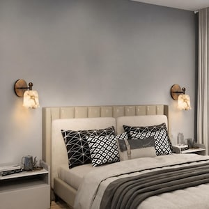 Modern brass wall sconce set with alabaster stone shade, minimalist bedroom wall lighting on grey background Mid century brass wall lights with white alabaster tulip shades, luxury wall sconce pair for bedroom decor Set of two brass wall sconces with natural alabaster shades, elegant modern wall lighting fixture Minimal brass wall lamps with alabaster shade, bedside wall lighting pair on neutral grey wall Luxury brass wall sconce pair with alabaster tulip glass shade, modern wall lighting.