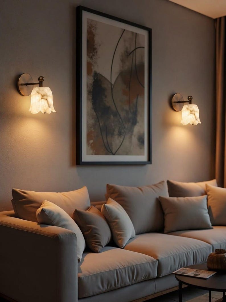 Modern brass wall sconce set with alabaster stone shade, minimalist bedroom wall lighting on grey background Mid century brass wall lights with white alabaster tulip shades, luxury wall sconce pair for bedroom decor Set of two brass wall sconces with natural alabaster shades, elegant modern wall lighting fixture Minimal brass wall lamps with alabaster shade, bedside wall lighting pair on neutral grey wall Luxury brass wall sconce pair with alabaster tulip glass shade, modern wall lighting.
