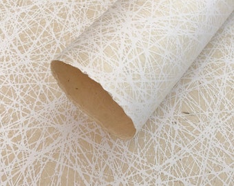 May include: A roll of white textured paper with a white, abstract, geometric pattern. The paper has a natural, organic look and feel.