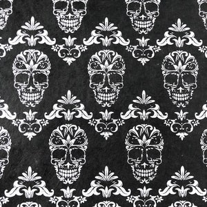 May include: Black and white patterned fabric with a repeating design of stylized skulls with floral details.