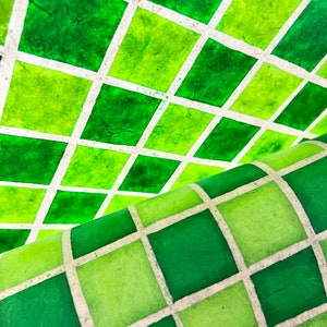 May include: Green and white checkered pattern paper with a textured surface. The paper is folded in half, creating a diagonal pattern.