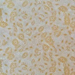 K&ouml;nnte beinhalten: Ein wei&szlig;er Hintergrund mit einem sich wiederholenden Muster aus goldenen G&auml;nsebl&uuml;mchen.