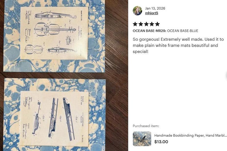 May include: Two rectangular frame mats featuring a blue and white marbled pattern. Each mat contains a centered off-white paper insert displaying black technical patent illustrations. The top insert shows a violin, and the bottom shows a flute.