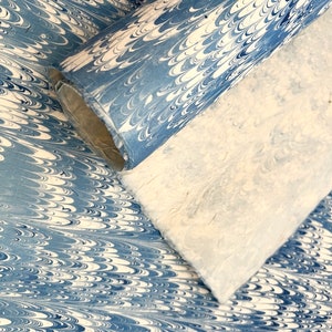 May include: Two rolls of marbled paper in shades of blue and white. The paper has a swirling pattern.