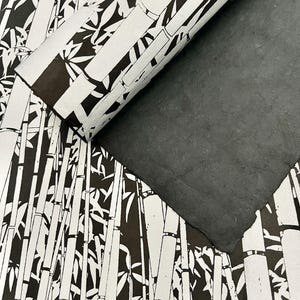 May include: Black and white wrapping paper with a bamboo design. The paper is rolled up and partially unrolled, revealing the black and white pattern.