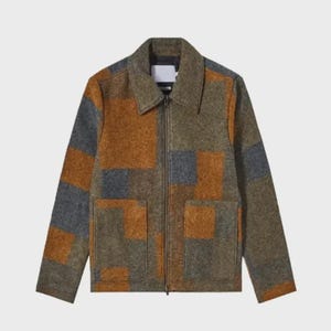 Peut inclure: Veste zippée avec un motif patchwork dans les tons marron, gris et vert. La veste a un col, deux poches avant et une étiquette blanche au dos du col.