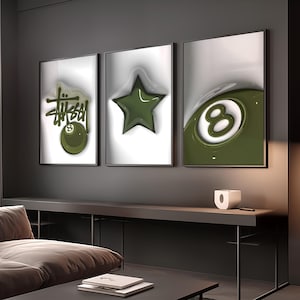 May include: Three framed wall art pieces. The left frame features the word "Stussy" in green with an 8-ball graphic. The center frame has a green star. The right frame shows a green 8-ball. All are on a white background.