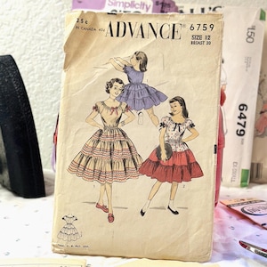 May include: A vintage Advance 6759 sewing pattern envelope featuring illustrations of three dresses with gathered skirts and short sleeves. The cream-colored paper envelope displays the text Advance 6759, Size 12, Breast 30, and 35 cents in Canada.