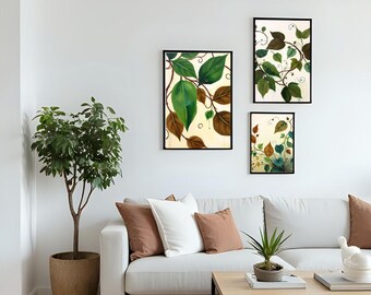 May include: Three framed botanical art prints featuring green and brown leaves on a cream background. The prints are displayed above a white sofa with brown and white pillows. A potted plant and a coffee table complete the living room scene.