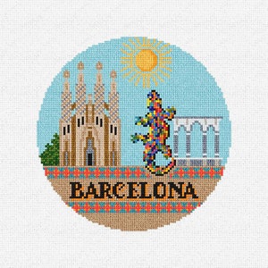 May include: A colorful cross-stitch design featuring a church, a lizard, and the word "BARCELONA". The design is set against a blue background with a yellow sun.