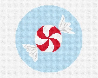 May include: A red and white peppermint candy design on a light blue background. The candy is in the center of a light blue circle, with white paper wrapping on each side. The image is a cross-stitch design.