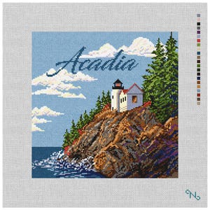 May include: A needlepoint canvas featuring a coastal scene with a lighthouse on a rocky cliff, evergreen trees, and the word Acadia in script. The design includes a blue sky with white clouds, dark water, and a color palette guide on the right side.
