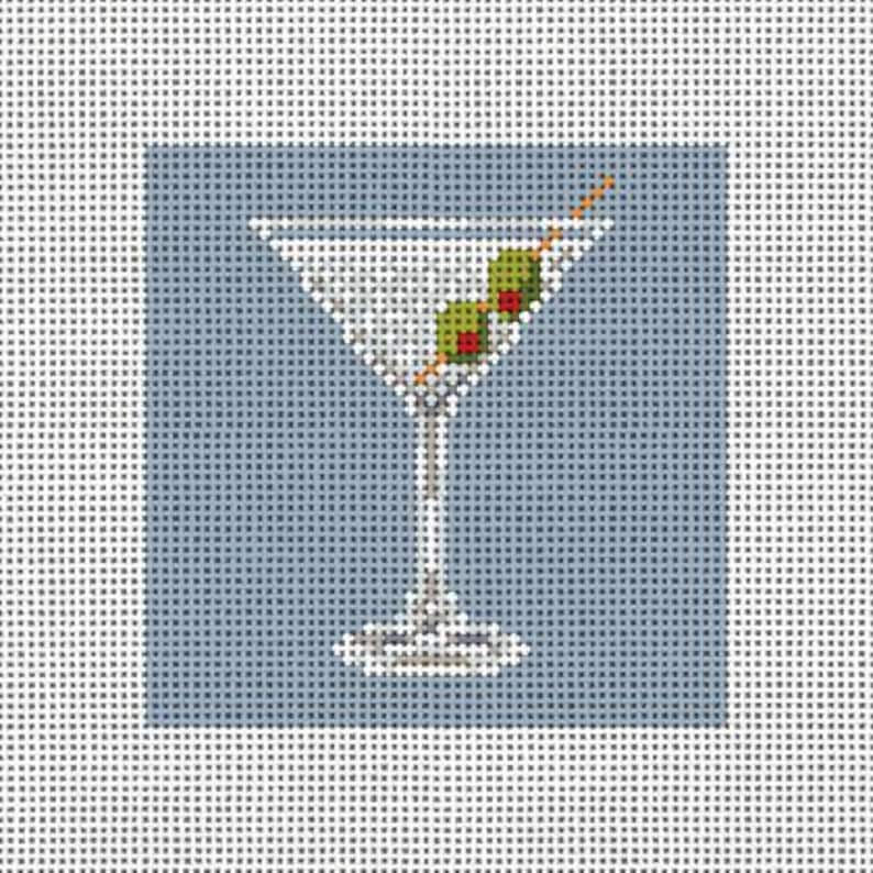 May include: A martini glass with a green olive on a toothpick, on a blue background.
