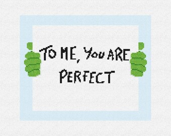 May include: A cross-stitch design on a white background with a light blue border. The text "TO ME, YOU ARE PERFECT" is in black, with green thumbs on either side of the text.