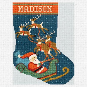 May include: A Christmas stocking with a festive design. The top band is orange with the name "MADISON" in white. The main body is dark blue with Santa Claus in a sleigh pulled by reindeer. The design is made with cross-stitch.