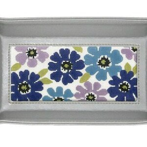 May include: A gray leather tray with a floral design. The design features blue, purple, and green flowers on a white background.