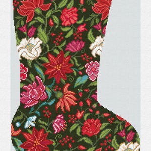 Könnte beinhalten: Ein Weihnachtsstrumpf mit dunkelgrünem Hintergrund, bedeckt mit einem Blumenmuster aus roten, rosa und weißen Blüten, mit grünen Blättern und Beeren. Das Wort "Madeline" ist oben grün gestickt.