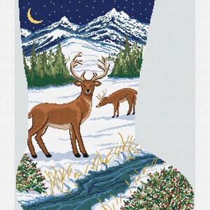 May include: A Christmas stocking with a winter scene featuring two deer in a snowy landscape. The stocking has a green top with the name "Alexander" and a blue and white mountain and forest design.