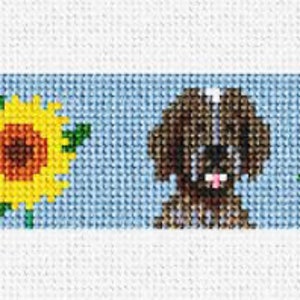 May include: A blue and white cross-stitch pattern featuring two brown dogs and sunflowers. The dogs are sitting and walking. The sunflowers are yellow with brown centers.