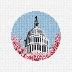 May include: A cross-stitch design of the US Capitol building with a blue sky background and pink cherry blossoms around the base.