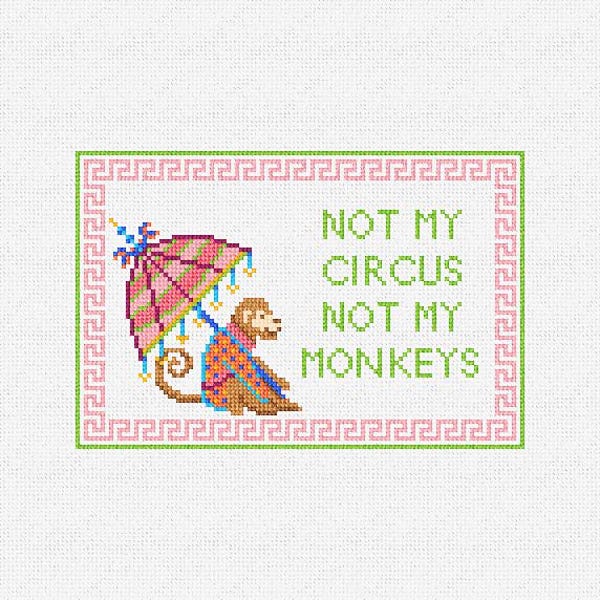Può includere: Un motivo a punto croce su tessuto bianco raffigurante una scimmia marrone che tiene un ombrello a righe rosa e verdi. Il testo recita NOT MY CIRCUS NOT MY MONKEYS in lettere verdi. Il disegno è racchiuso in un bordo greco rosa.