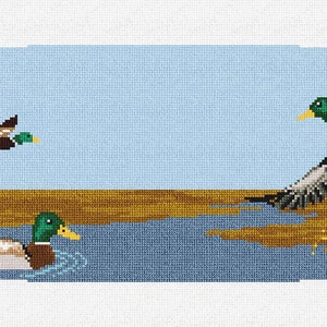 May include: A needlepoint design featuring three mallard ducks in a pond setting. The ducks are depicted in shades of brown, green, and white, with a blue background. The pond is surrounded by brown reeds and green grass.