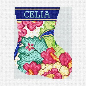 May include: A needlepoint Christmas stocking with a floral design in shades of pink, green, and yellow. The top band is navy blue with the name "CELIA" embroidered in light blue.