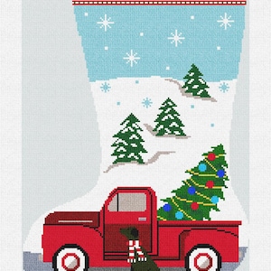 May include: Christmas stocking with a red truck carrying a decorated Christmas tree. The stocking has a light blue background with snowflakes and the name "JUSTIN" at the top. A black dog with a scarf sits beside the truck.