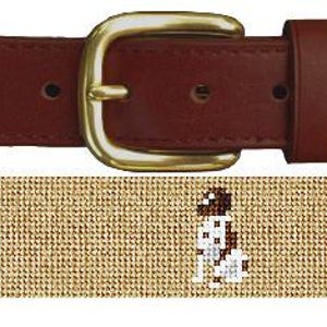May include: A brown leather belt with a gold buckle. The belt is woven with a tan fabric and features a repeating pattern of brown and white dogs.
