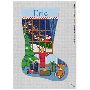 Op de afbeelding: Een naaldpunt kerstkous canvas met de naam Eric bovenaan. Het ontwerp toont een kind in rode pyjama dat uit een raam kijkt naar de kerstman in een slee met rendieren. Een groene kerstboom, ingepakte cadeaus, een speelgoedtrein en een teddybeer zijn onderaan zichtbaar.