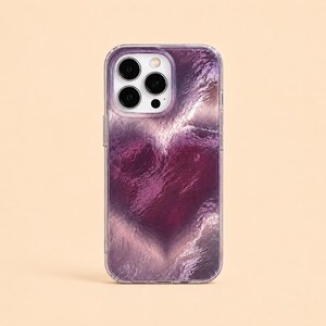 May include: A clear phone case with a vibrant, abstract design. The case features a swirling pattern of deep purple and lavender hues, creating a textured, artistic appearance. The phone's camera lenses are visible.