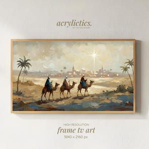 Peut inclure: Peinture de paysage encadrée représentant trois personnages à dos de chameaux traversant un désert vers une ville. L'œuvre, aux tons chauds, comprend des palmiers et une étoile brillante. Le texte "acrylictics" est en haut.