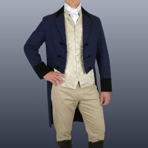 May include: A navy blue tailcoat with black accents, paired with a cream-colored vest and khaki pants. The coat features black cuffs and buttons. The outfit is completed with a white ascot.