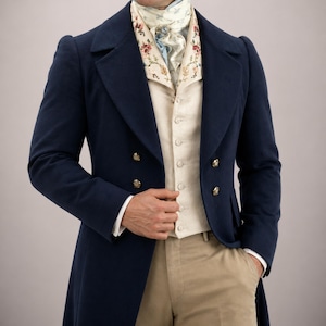 Puede incluir: Un abrigo azul marino de doble botonadura con botones dorados, combinado con un chaleco color crema y una corbata estampada. El conjunto se completa con pantalones color caqui. Un ejemplo clásico de vestimenta formal histórica.