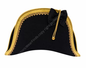 Puede incluir: Un sombrero bicornio negro con ribete dorado y un lazo negro. El sombrero presenta una cuerda dorada con una bola dorada. Accesorio de vestuario histórico.