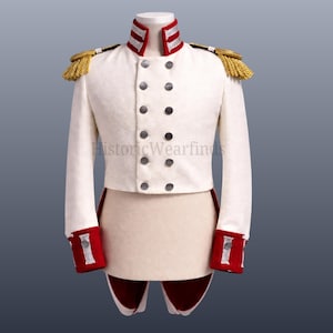 Puede incluir: Chaqueta militar blanca con charreteras doradas, rayas rojas y blancas en el cuello y puños rojos. La chaqueta tiene un frente cruzado con botones oscuros. El texto "HistoricWearfinds" es visible.
