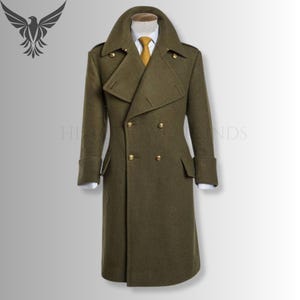May include: An olive green double-breasted overcoat with gold buttons. The coat has a wide collar, two front pockets, and a tailored fit. The long coat reaches the ankles and is displayed on a mannequin. A yellow tie is visible.