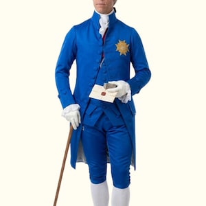 Può includere: Un vivace costume storico blu con un cappotto lungo, calzoni abbinati e un emblema dorato decorativo. L'outfit include una camicia bianca con volant, guanti e calze bianche. Un bastone di legno e una busta sigillata completano l'ensemble.