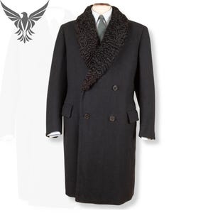 May include: A dark grey double-breasted overcoat with a black fur collar. The coat features two rows of buttons, two front pockets, and long sleeves. The coat is displayed on a mannequin.