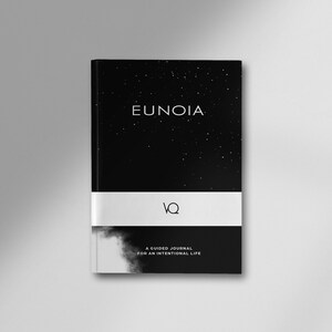 May include: A hardcover journal with a black cover featuring the word "EUNOIA" in white, and a starry night sky design. A white band with the letters "VQ" is centered. The bottom of the journal has the text "A GUIDED JOURNAL FOR AN INTENTIONAL LIFE."
