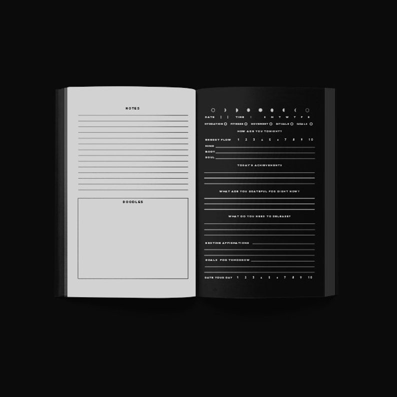 May include: Open journal with black pages and white text. The left page has space for notes and doodles. The right page includes sections for daily tracking, including mood, achievements, and affirmations. The journal is open against a black background.