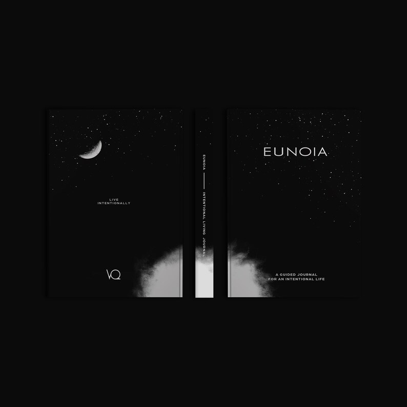 May include: A black journal with the word "EUNOIA" in white on the cover, along with a starry sky design. The journal's spine reads "EUNOIA INTERNATIONAL LIVING JOURNAL". The front cover features a crescent moon and the words "LIVE INTENTIONALLY".