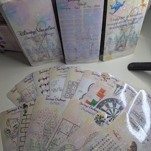 May include: A selection of Disney-themed savings challenge cards. The cards display Disney characters and phrases, including "Disney Vacation" and "Laughter is timeless, imagination has no age, dreams are forever."