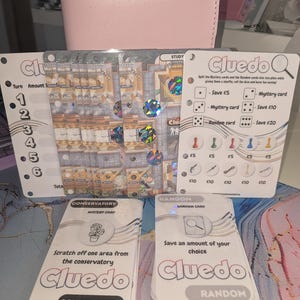 May include: A Cluedo board game set with cards and a game board. The board shows a detailed house map. The cards include "Mystery Card" and "Random Card" with instructions. Game pieces and dice are also visible.