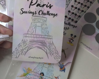 Op de afbeelding: Een verzameling Disney-thema spaarkaarten. De hoofdpas toont de Eiffeltoren, Tinkerbell en de tekst "Disney Vacation Paris Savings Challenge". Andere kaarten hebben Mickey Mouse oren en andere Disney-personages.