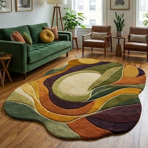 May include: An abstract area rug with a unique, organic shape. The rug features a blend of colors, including green, yellow, orange, and purple, arranged in flowing, layered patterns. The rug is placed on a hardwood floor, complementing the room's decor.