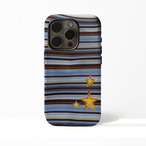 Op de afbeelding: Een smartphonehoesje met een horizontaal gestreept patroon in tinten bruin, lichtblauw en crème. Drie gele, vijfpuntige sterren zijn aan de rechteronderkant gedrukt, met een kleinere ster die deels zichtbaar is bij de cameralens.