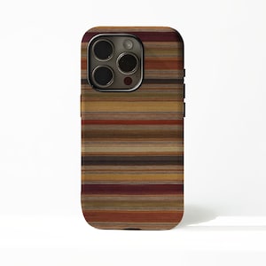 May include: A smartphone case featuring a horizontal striped pattern in earthy tones including deep burgundy, burnt orange, mustard yellow, olive green, and various shades of brown. The case has a cutout for a triple-lens camera system.